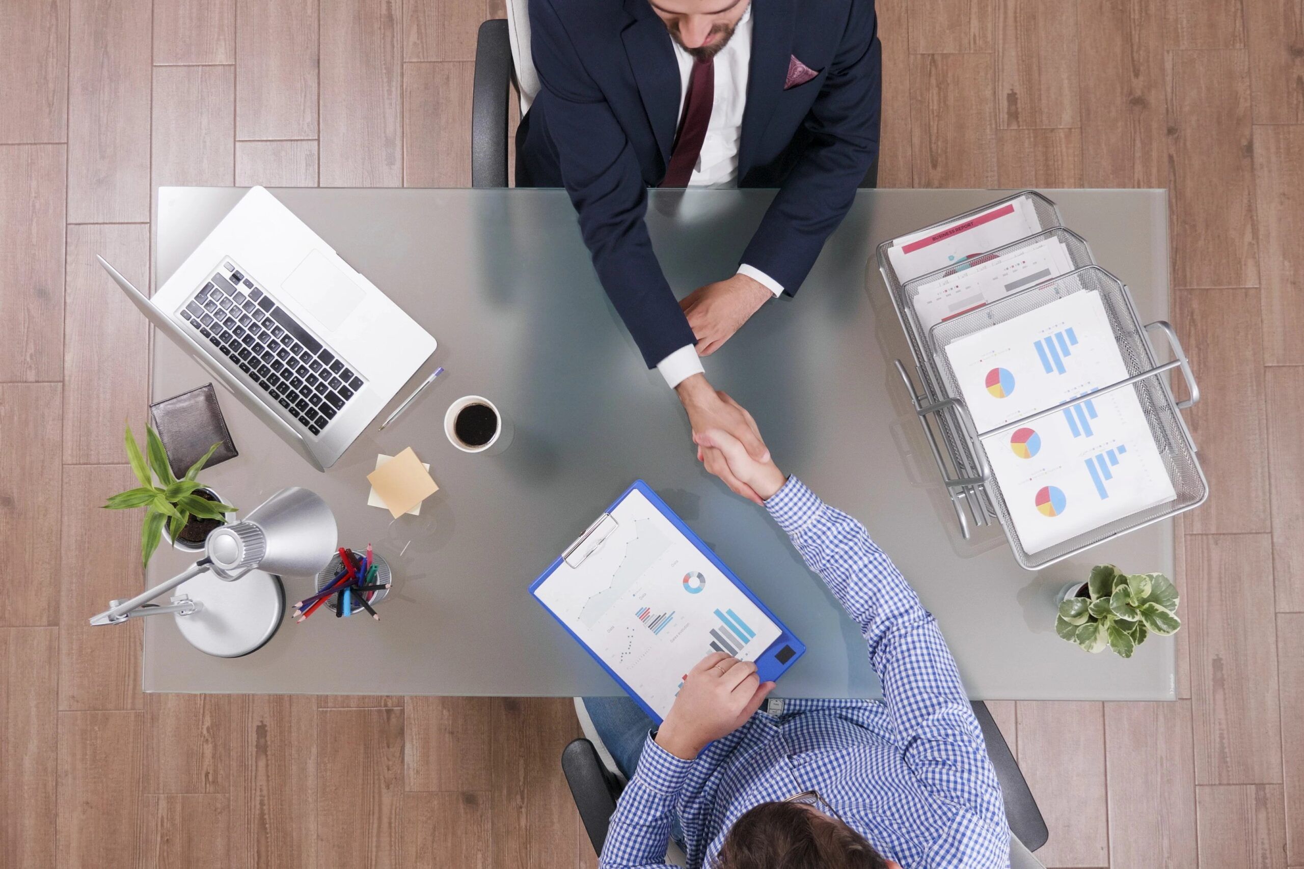 top-view-businessmen-shaking-hands-business-negotiation-startup-office